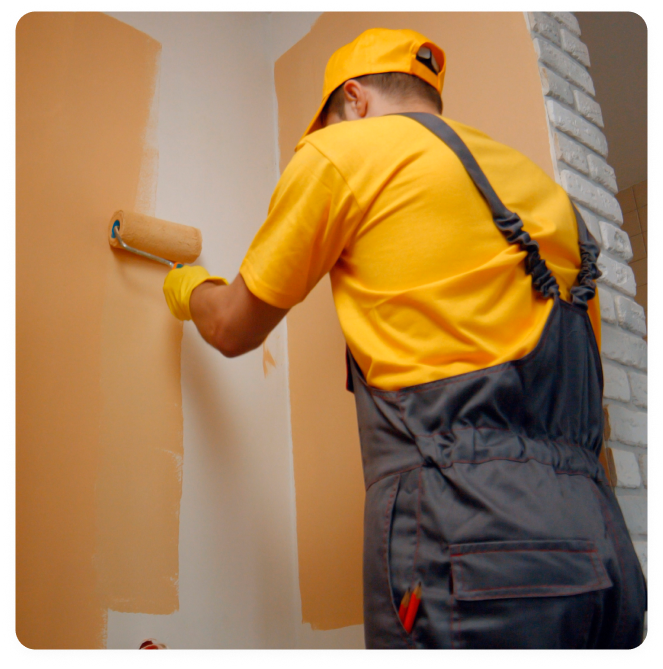 Painter rolling a second coat on an interior wall for smooth, even coverage