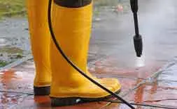 Close-up pressure washing pavers to restore a clean surface